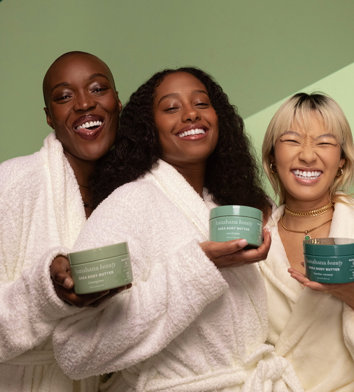 Three women in robes holding Hanahana Beauty body butters